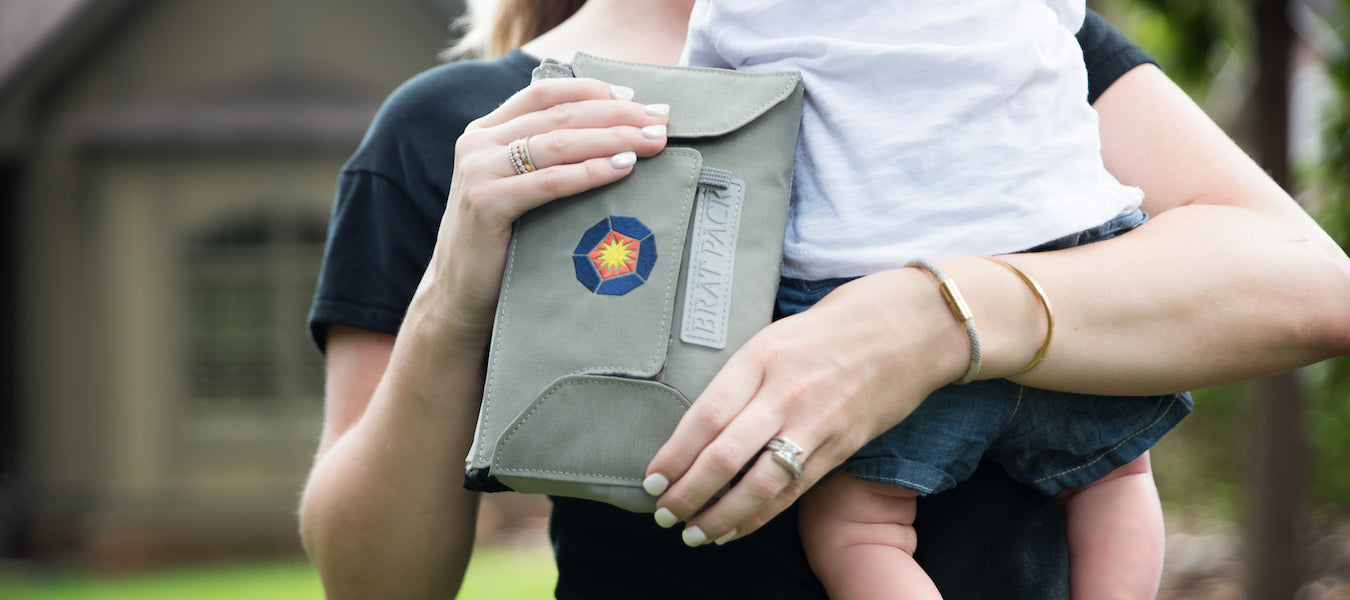 Woman holding bratpack diaper bag and baby